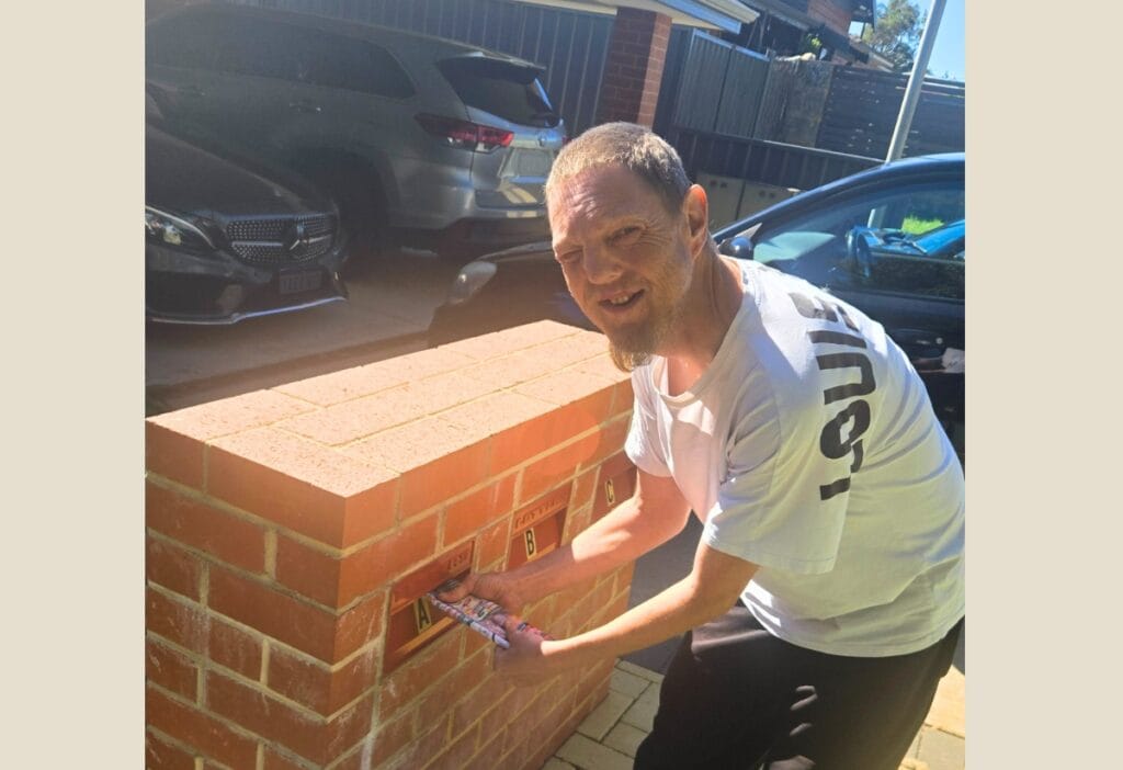 Image of a man delivering a catalogue and smiling at the camera.