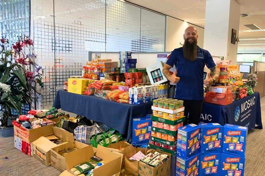 Image of Zak with all the food donation from the Mosaic's team to the Foodbank WA